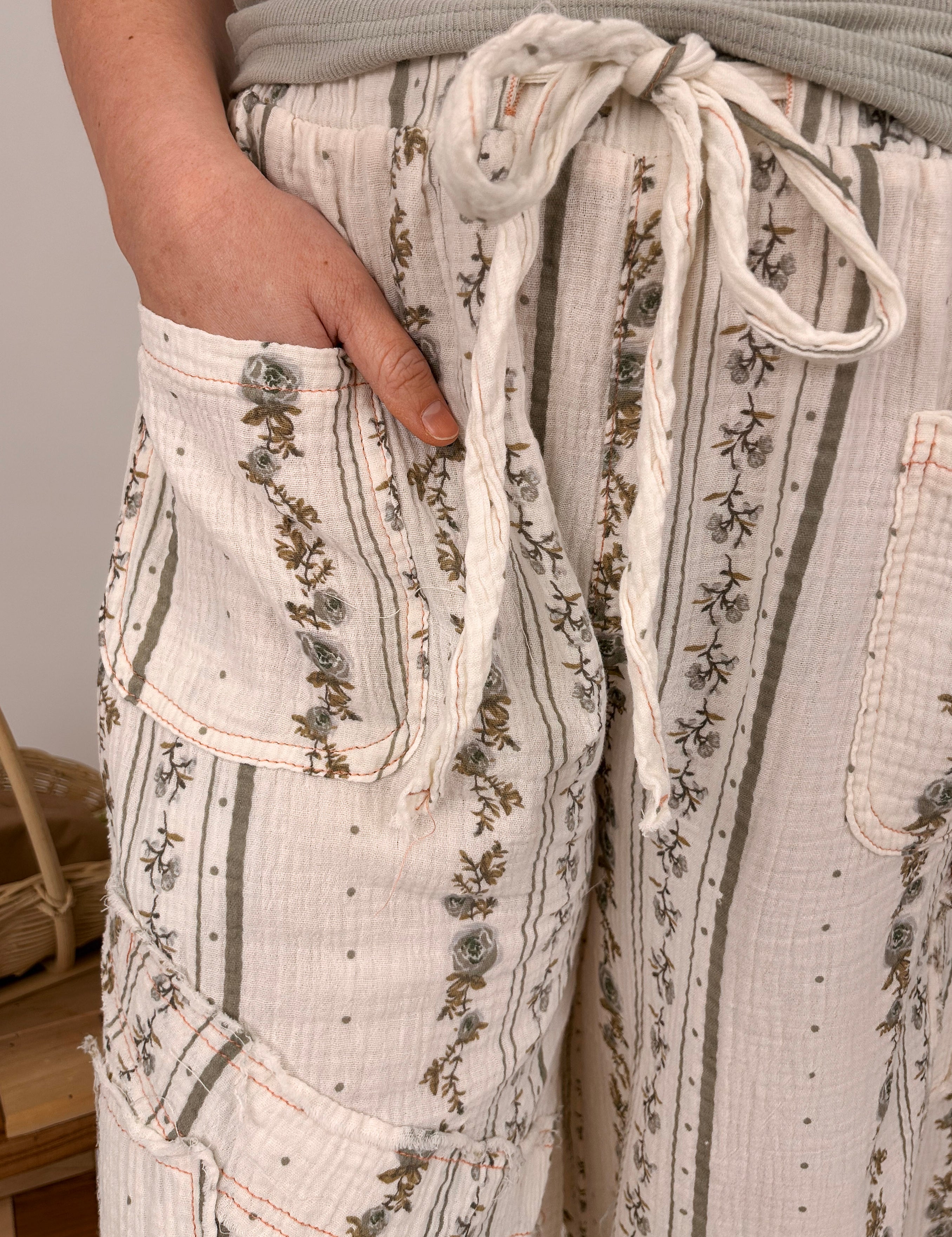 Woman wearing cream Avery Floral Detail Jogger with wide leg fit, drawstring waist, pockets, and delicate floral embroidery at hem