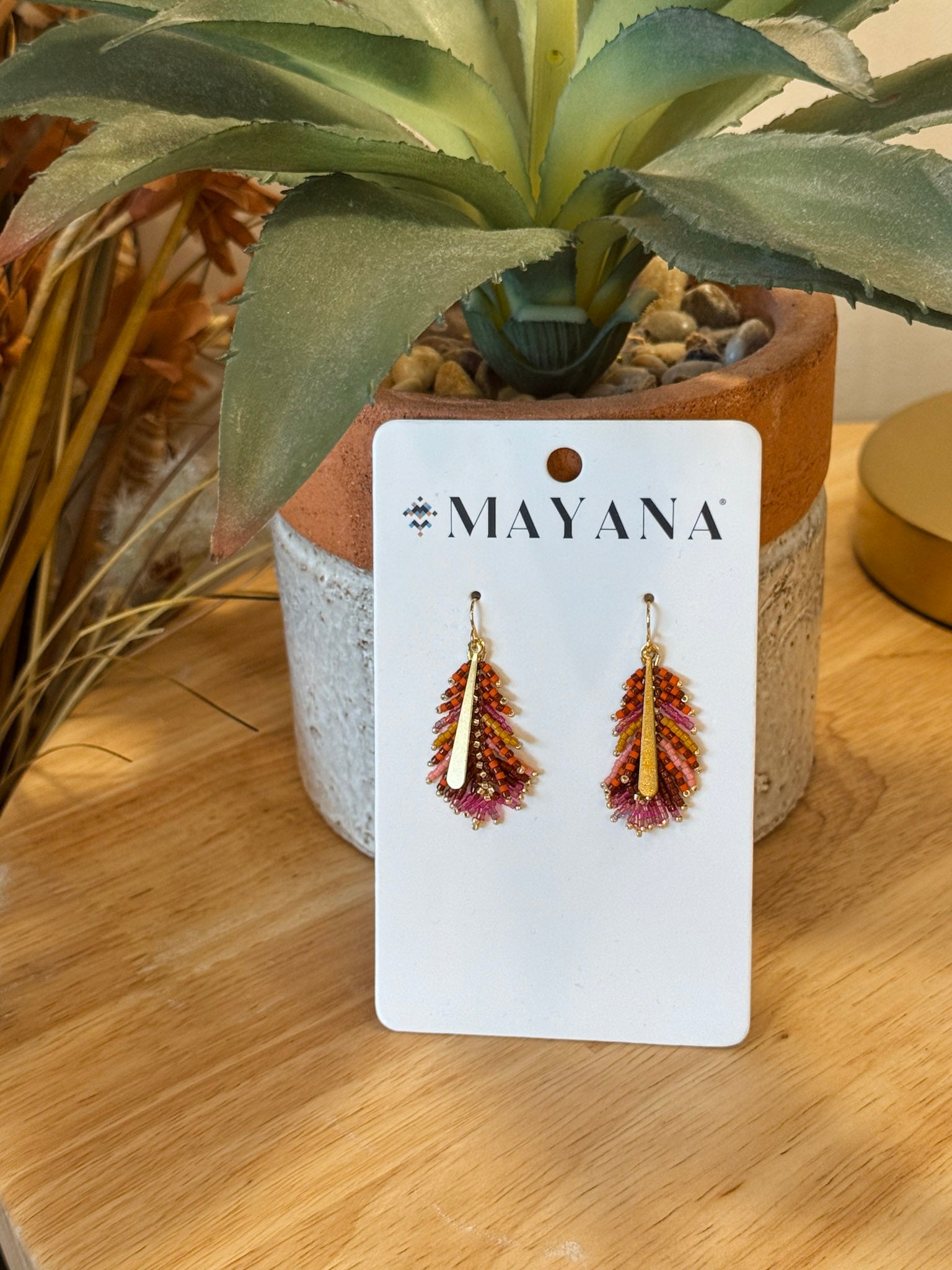 Gilded Feather Earrings in warm rust, magenta, and mustard beadwork with a gold quill center — Paper Doll