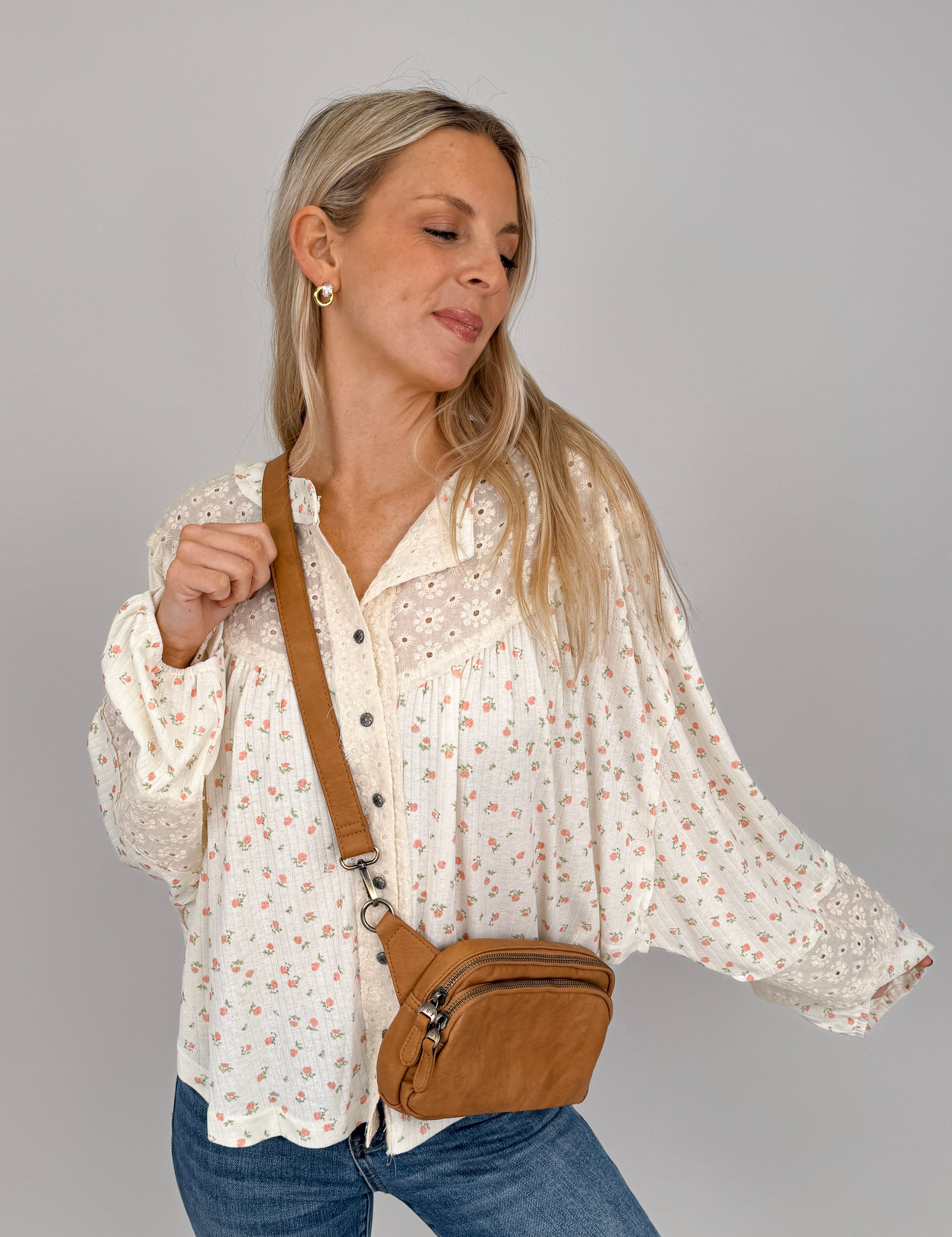 Woman wearing cream Small Town Girl Knit Top with ditsy floral print, eyelet lace yoke detail, button-front placket, and ruffle cuffs