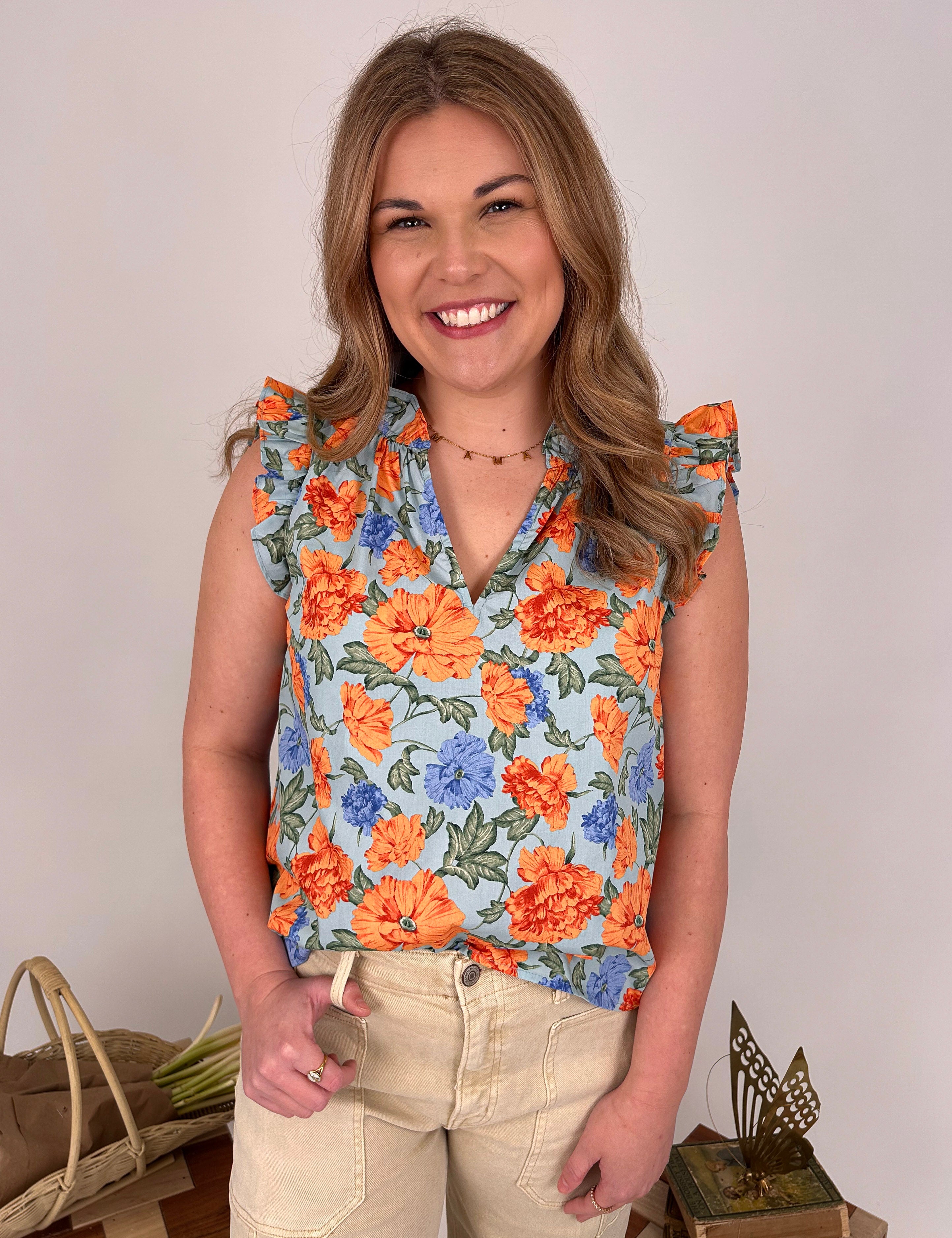 Kelsie Floral Blouse in sky blue with orange and blue florals - woman wearing cotton V-neck top with ruffle sleeves