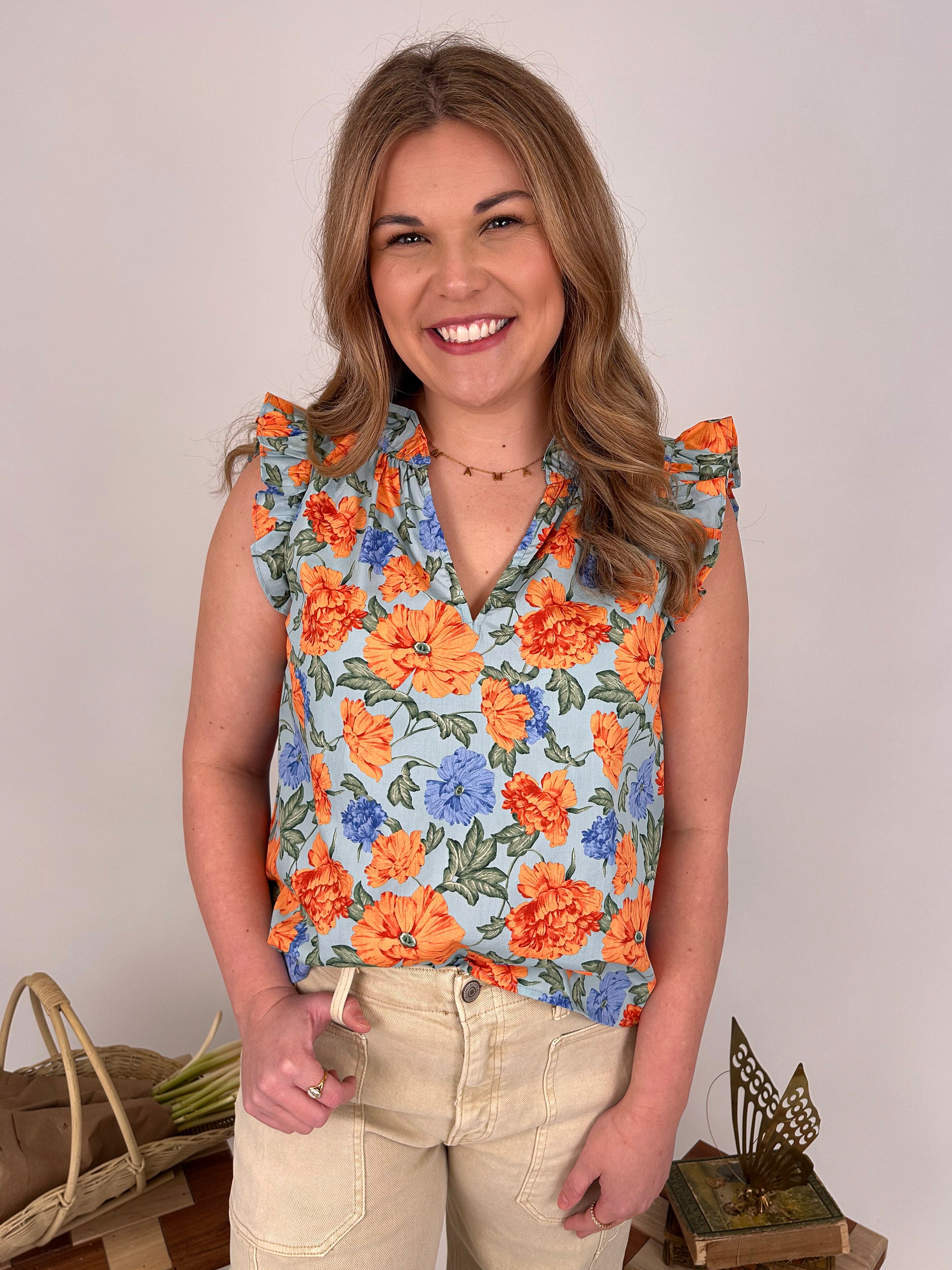 Kelsie Floral Blouse in sky blue with orange and blue florals - woman wearing cotton V-neck top with ruffle sleeves