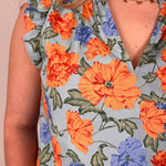 Close-up of a floral dress with orange and blue flowers on a light background
