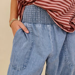Annie Denim Casual Pants in light wash denim with smocked waist and barrel leg — Paper Doll
