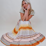 Sunset Tiered Maxi Skirt in an ombré sunset stripe of peach, gold, and rust — Paper Doll
