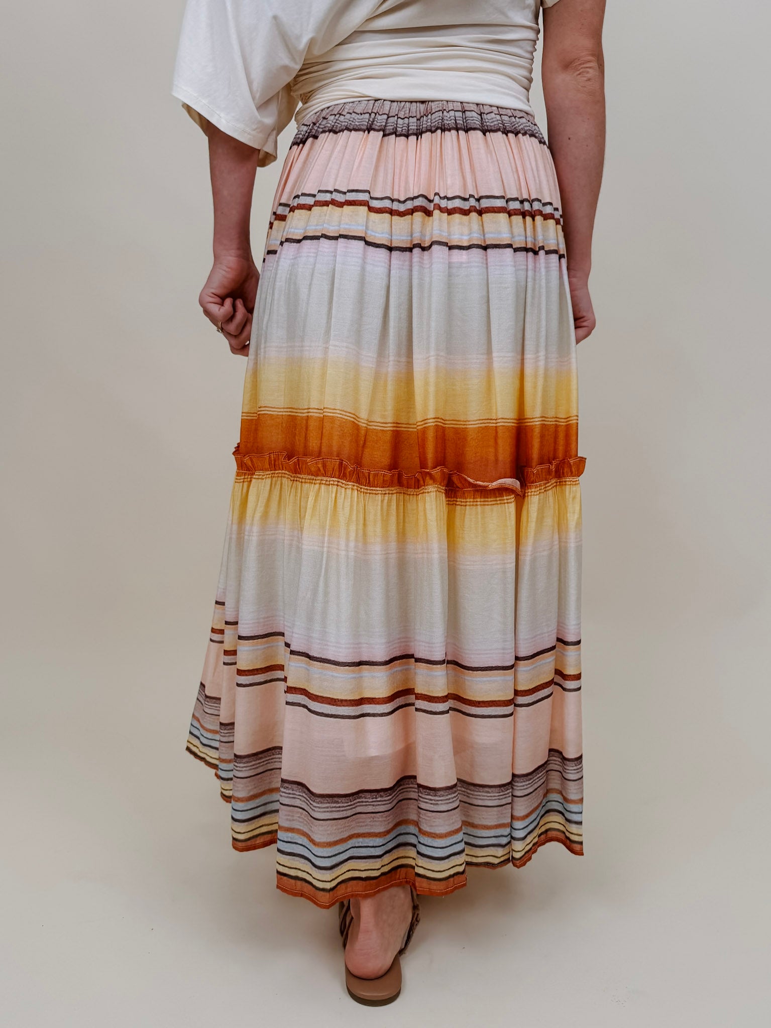 Sunset Tiered Maxi Skirt in an ombré sunset stripe of peach, gold, and rust — Paper Doll
