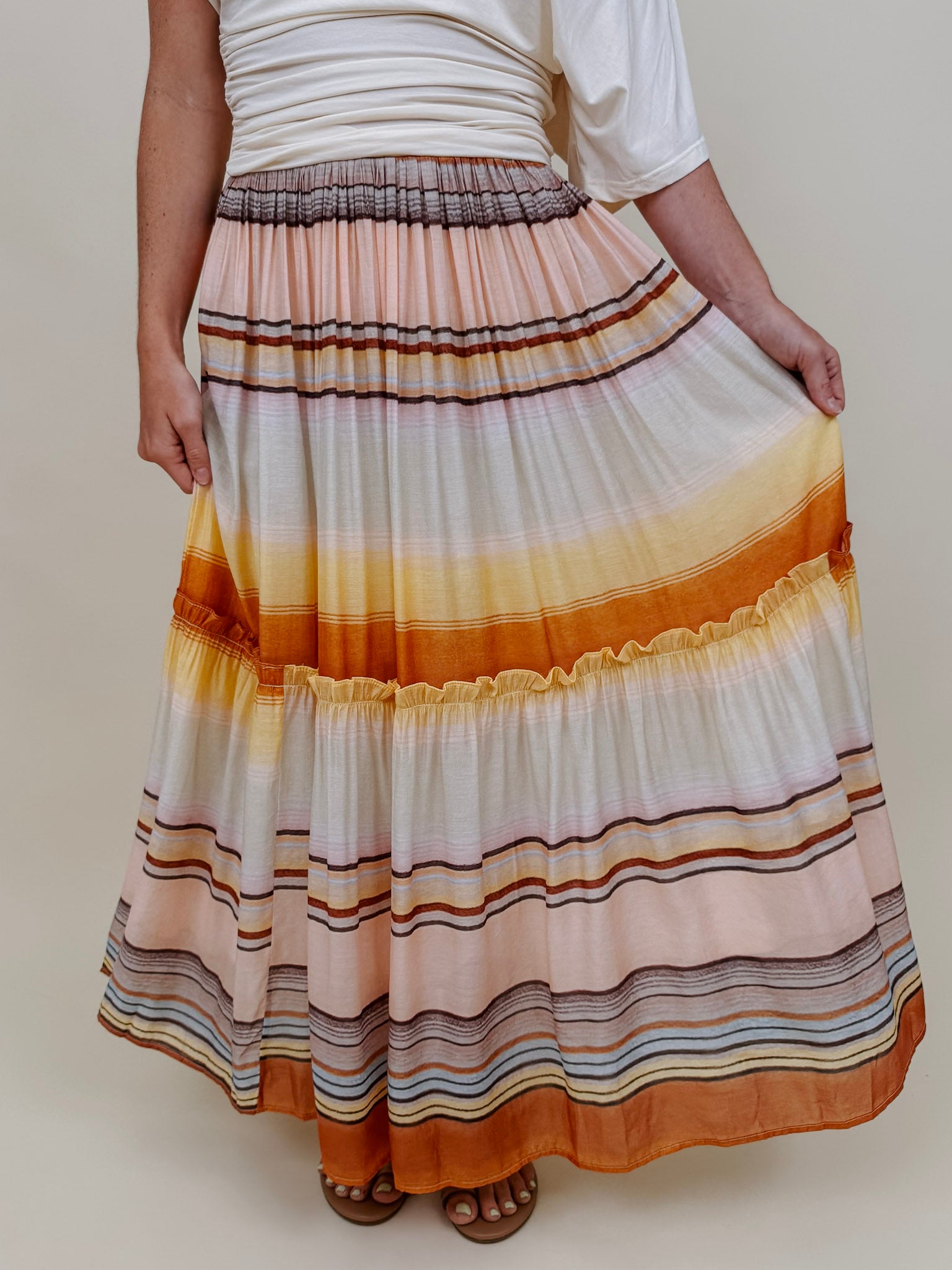 Sunset Tiered Maxi Skirt in an ombré sunset stripe of peach, gold, and rust — Paper Doll
