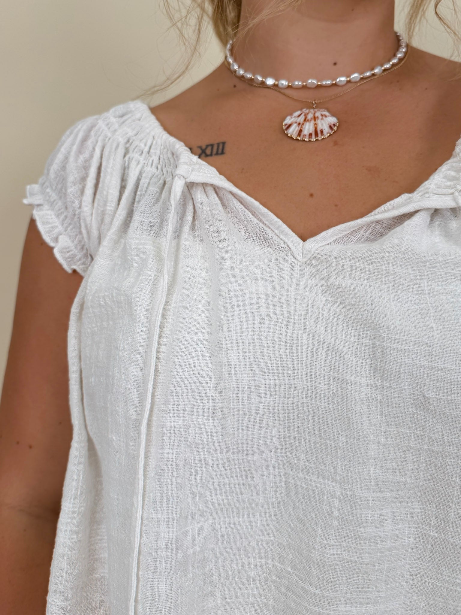 Hadleigh Smocked Neckline Blouse in white with tie neckline and flutter sleeves — Paper Doll