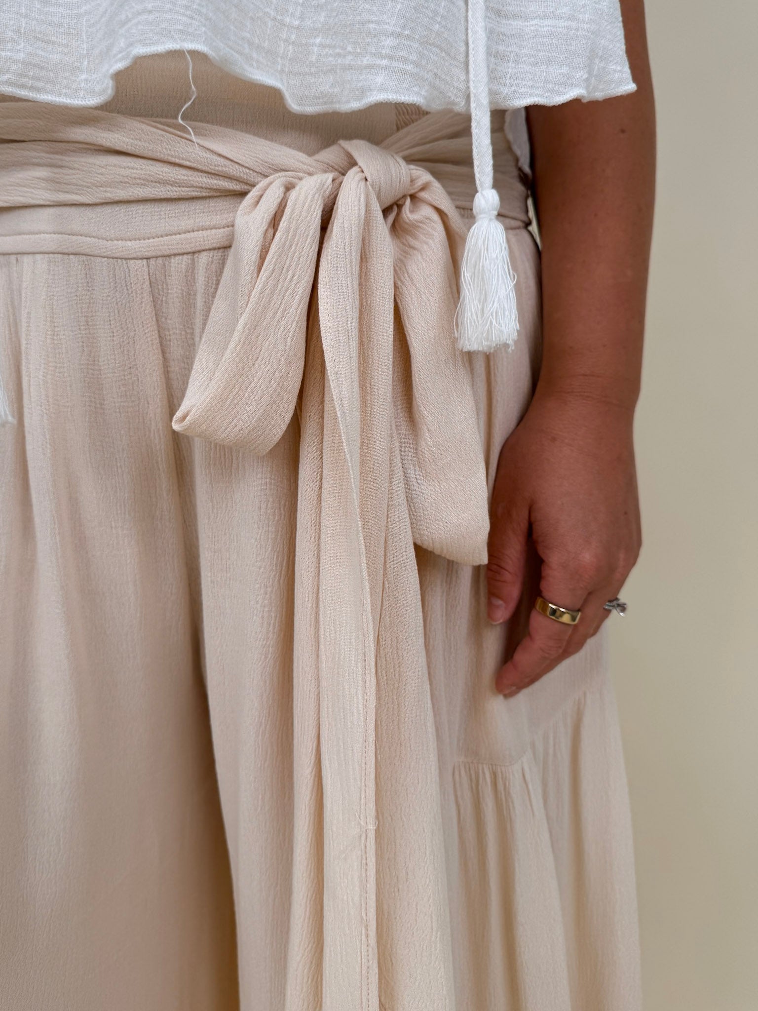 Evanthe Tie-Waist Wide Leg Pants in cream with tiered wide-leg and tassel tie — Paper Doll
