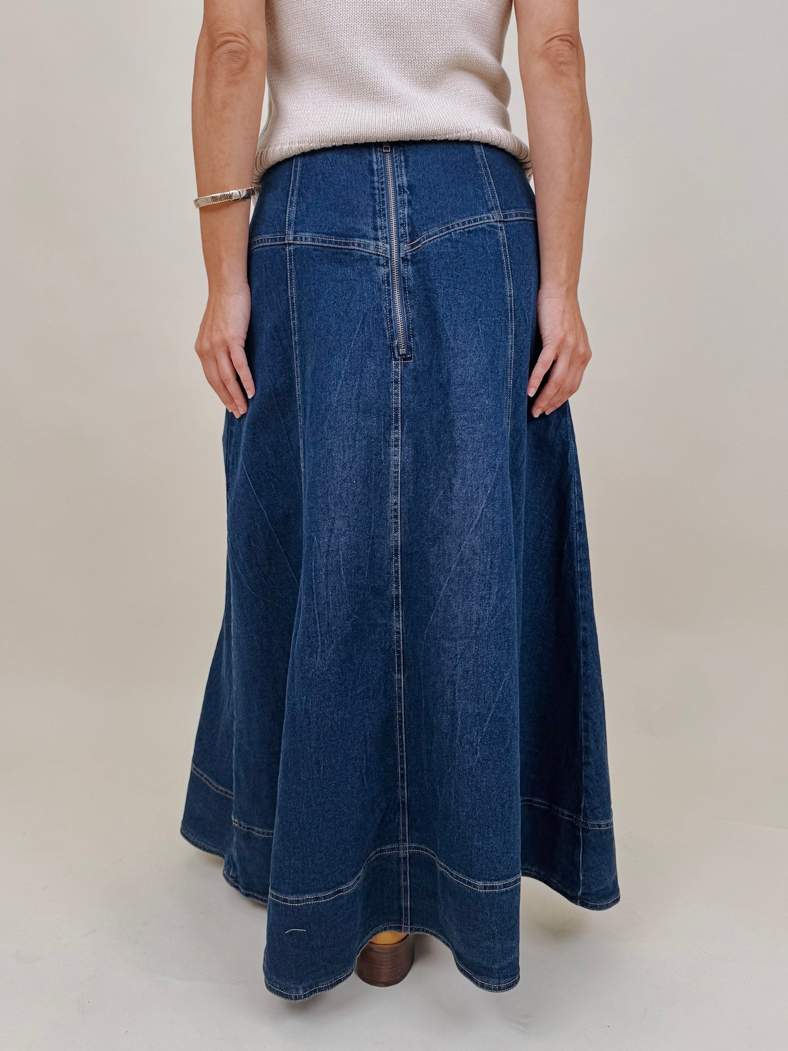 Belhaven Skirt in dark wash denim with a corset style lace up front, deep patch pockets, seamed panels, and a full sweeping maxi length