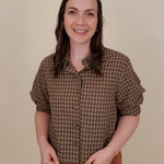 Belle Plaid Button Up Top in chocolate brown and cream windowpane plaid with covered buttons, a ruffled collar, and cuffed short sleeves