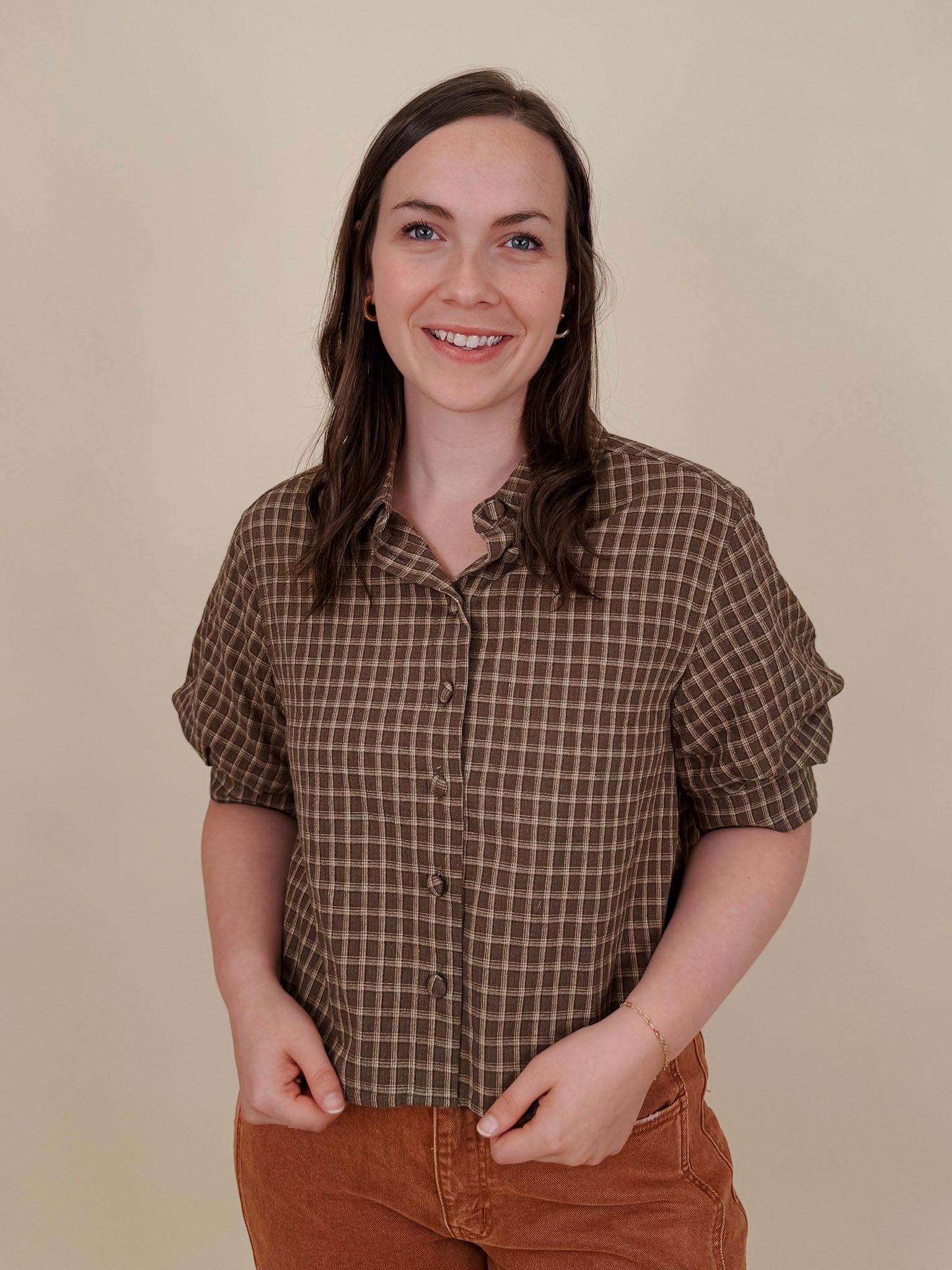 Belle Plaid Button Up Top in chocolate brown and cream windowpane plaid with covered buttons, a ruffled collar, and cuffed short sleeves