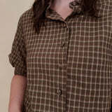 Belle Plaid Button Up Top in chocolate brown and cream windowpane plaid with covered buttons, a ruffled collar, and cuffed short sleeves