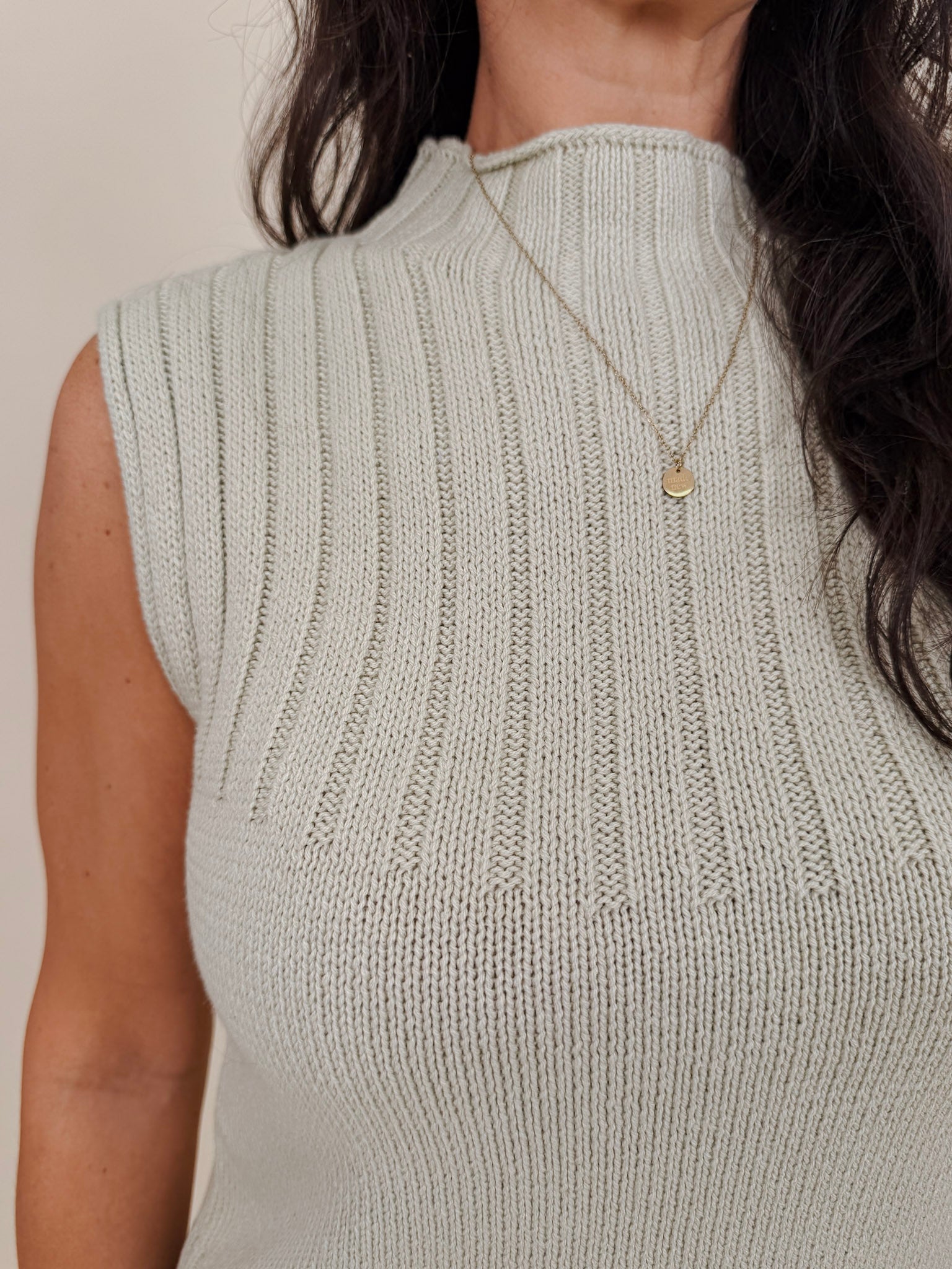Blair Mock Neck Knit Top in soft light green with a textured rib knit, mock neckline, sleeveless cap shoulders, and a ribbed waist hem