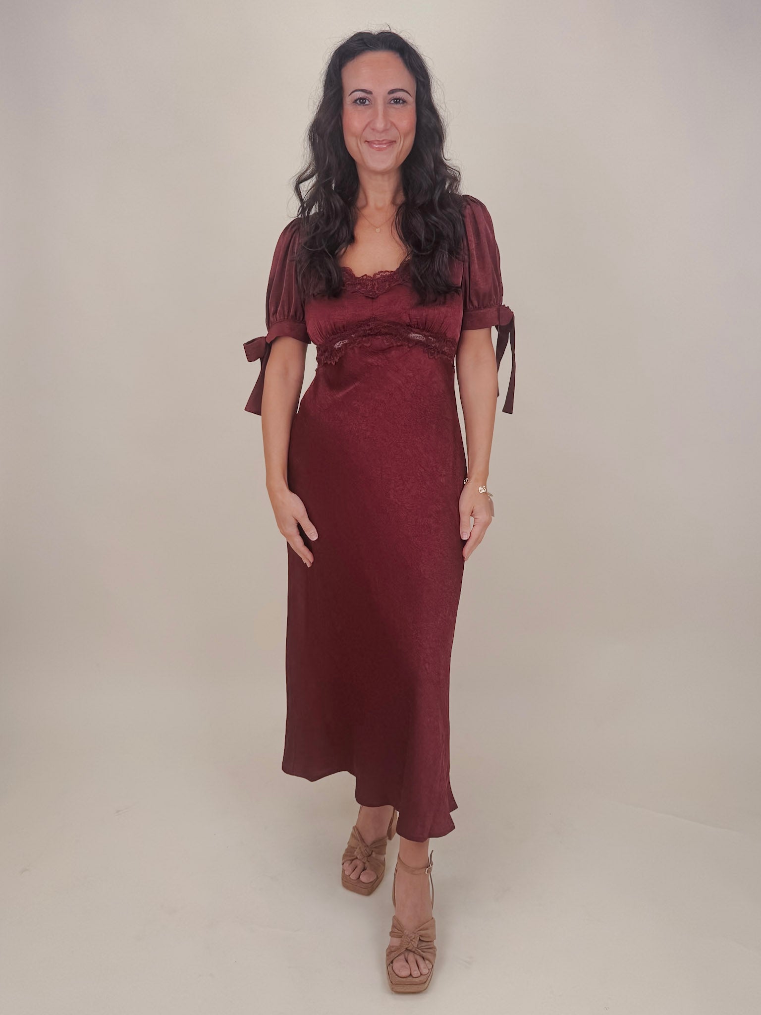 Katrina Midi Dress in olive crinkled satin with lace trim at the sweetheart neckline and empire waist, puff sleeves with bow ties, and a flowing bias cut midi skirt