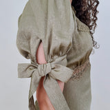Katrina Midi Dress in olive crinkled satin with lace trim at the sweetheart neckline and empire waist, puff sleeves with bow ties, and a flowing bias cut midi skirt
