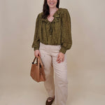 Kortni Blouse in martini olive with tonal brown polka dots, a ruffle collar, tie front V neckline, and balloon sleeves