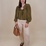 Kortni Blouse in martini olive with tonal brown polka dots, a ruffle collar, tie front V neckline, and balloon sleeves