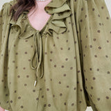Kortni Blouse in martini olive with tonal brown polka dots, a ruffle collar, tie front V neckline, and balloon sleeves