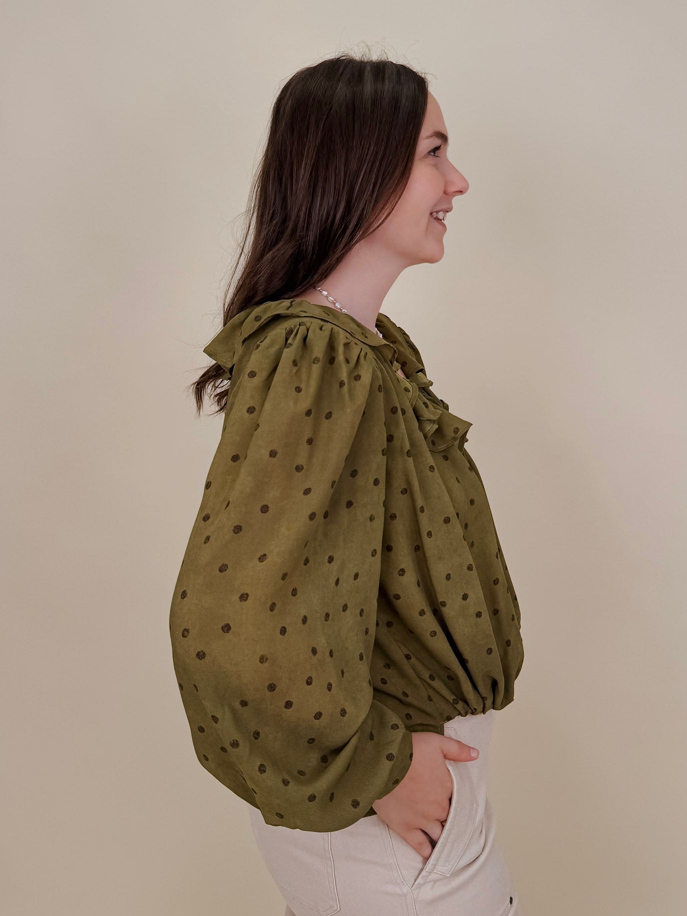 Kortni Blouse in martini olive with tonal brown polka dots, a ruffle collar, tie front V neckline, and balloon sleeves