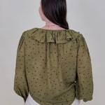 Kortni Blouse in martini olive with tonal brown polka dots, a ruffle collar, tie front V neckline, and balloon sleeves