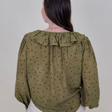 Kortni Blouse in martini olive with tonal brown polka dots, a ruffle collar, tie front V neckline, and balloon sleeves