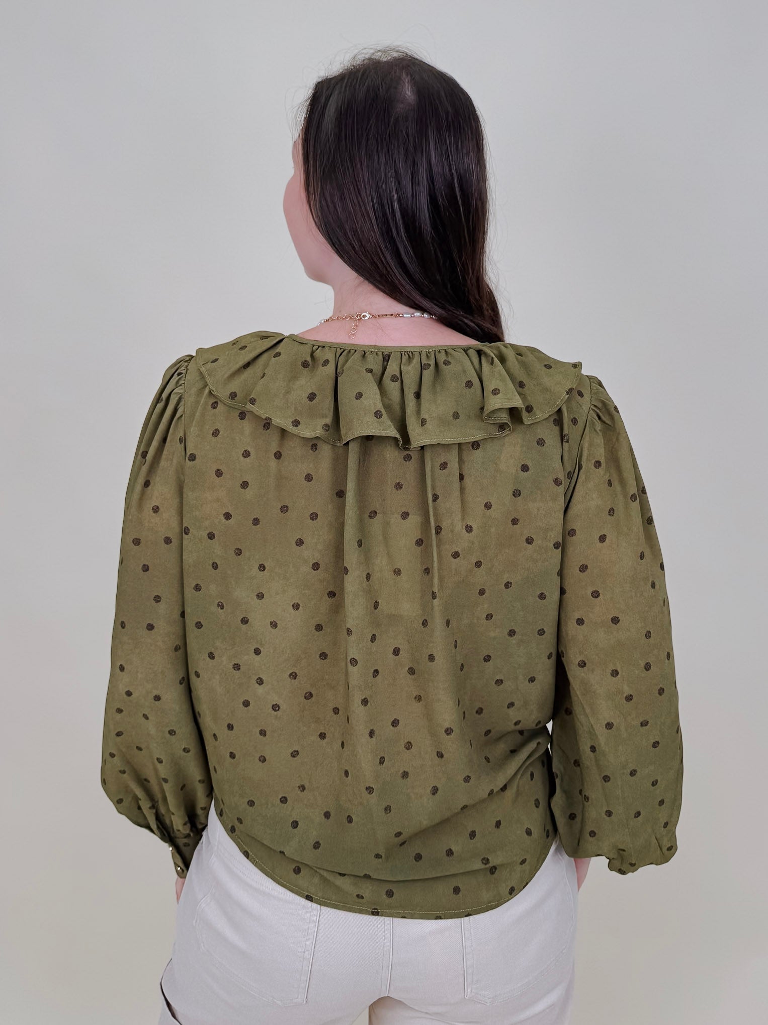 Kortni Blouse in martini olive with tonal brown polka dots, a ruffle collar, tie front V neckline, and balloon sleeves