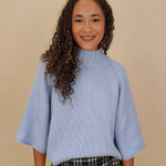 Long Island Sweater in powder blue with a folded ribbed mock neck, wide bell sleeves, and a relaxed boxy cotton knit body