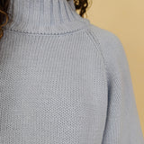 Long Island Sweater in powder blue with a folded ribbed mock neck, wide bell sleeves, and a relaxed boxy cotton knit body