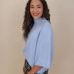 Long Island Sweater in powder blue with a folded ribbed mock neck, wide bell sleeves, and a relaxed boxy cotton knit body