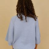 Long Island Sweater in powder blue with a folded ribbed mock neck, wide bell sleeves, and a relaxed boxy cotton knit body