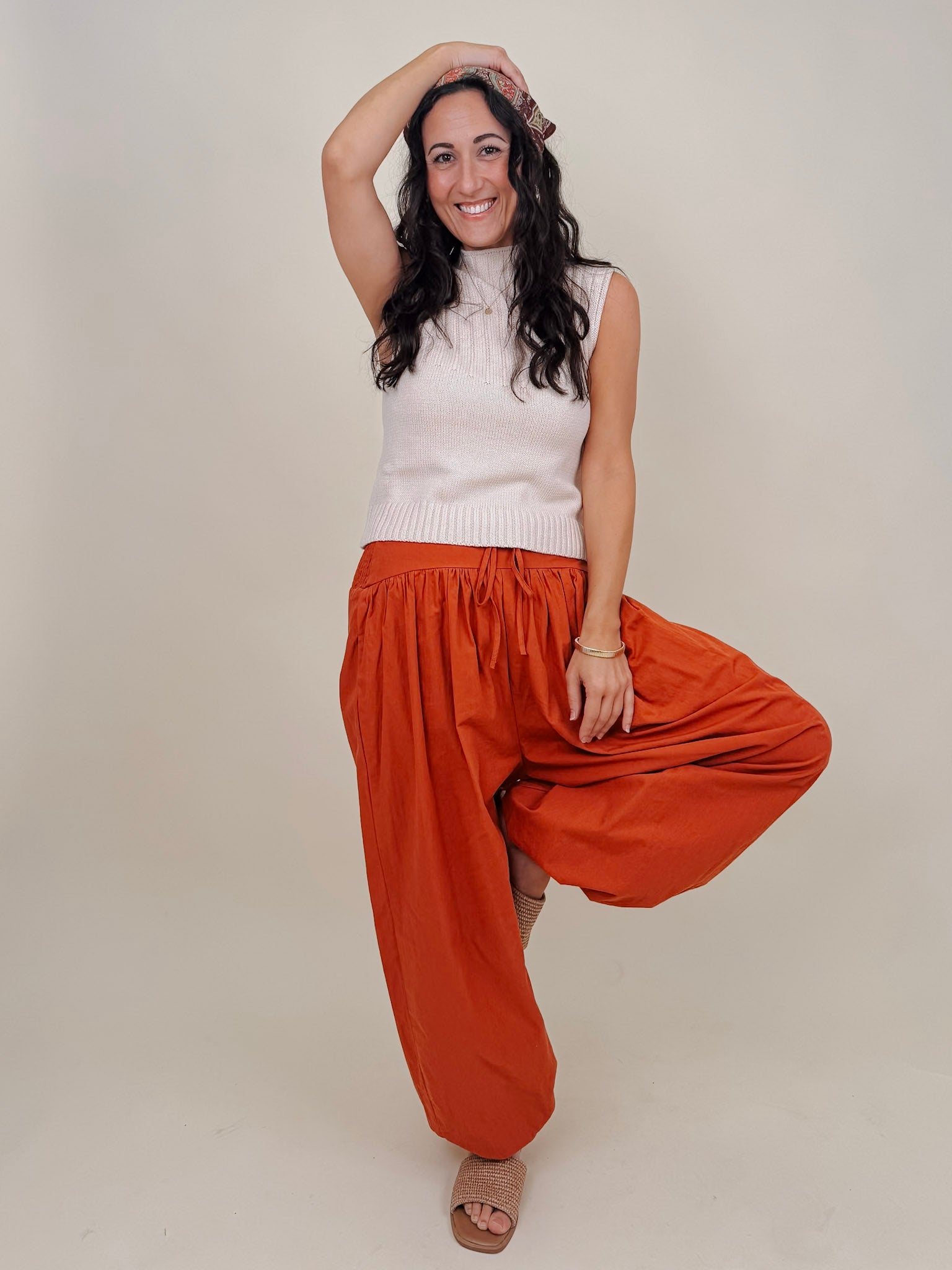 Magazine Street Pant in rust cotton with a smocked drawstring waist, gathered yoke, side pockets, and a full balloon leg