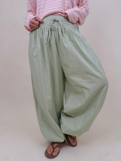 Magazine Street Pant in light olive cotton with a smocked drawstring waist, gathered yoke, side pockets, and a full balloon leg