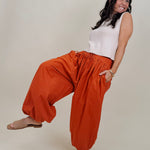 Magazine Street Pant in rust cotton with a smocked drawstring waist, gathered yoke, side pockets, and a full balloon leg