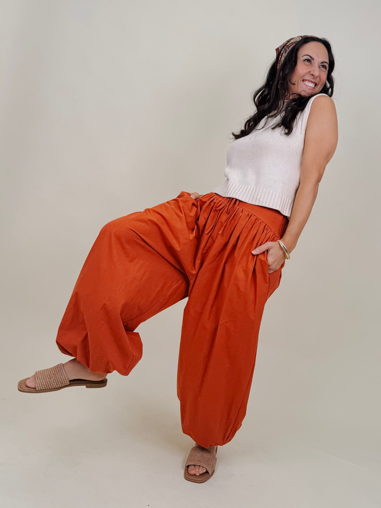 Magazine Street Pant in rust cotton with a smocked drawstring waist, gathered yoke, side pockets, and a full balloon leg