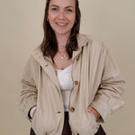 Pumpkin Patch Denim Jacket in soft beige with tortoise buttons over a hidden zip front, gathered shoulders, welt pockets, and an elastic bubble hem