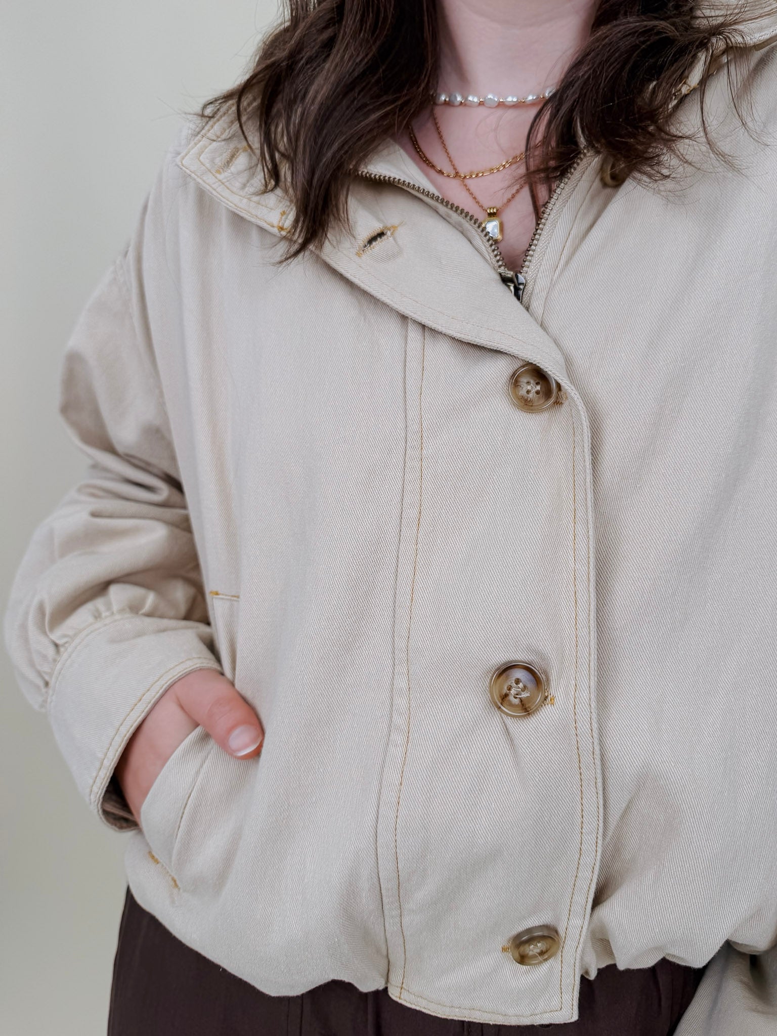 Pumpkin Patch Denim Jacket in soft beige with tortoise buttons over a hidden zip front, gathered shoulders, welt pockets, and an elastic bubble hem