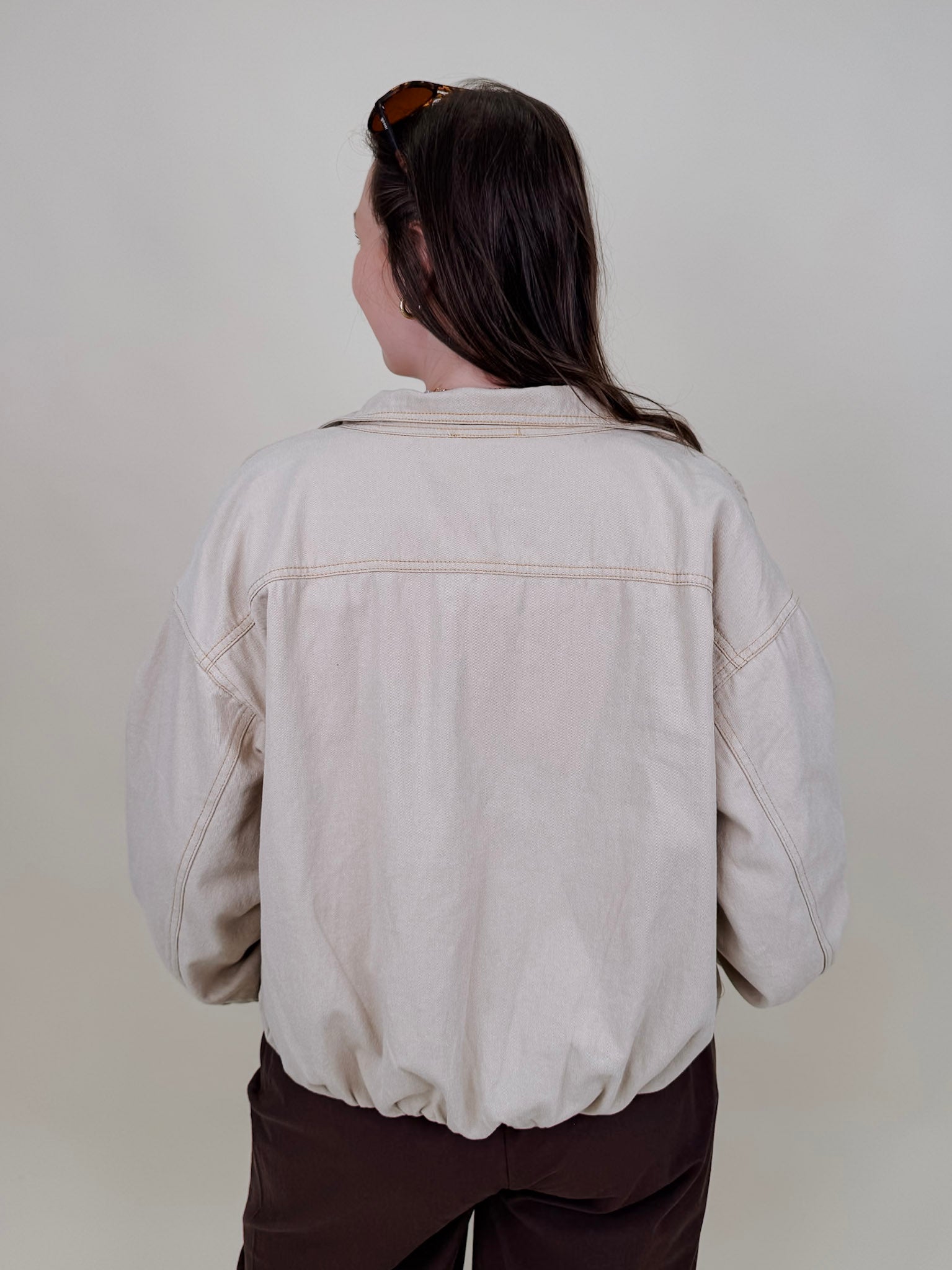 Pumpkin Patch Denim Jacket in soft beige with tortoise buttons over a hidden zip front, gathered shoulders, welt pockets, and an elastic bubble hem