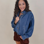 Pumpkin Patch Denim Jacket in medium wash denim with tortoise buttons over a hidden zip front, gathered shoulders, welt pockets, and an elastic bubble hem