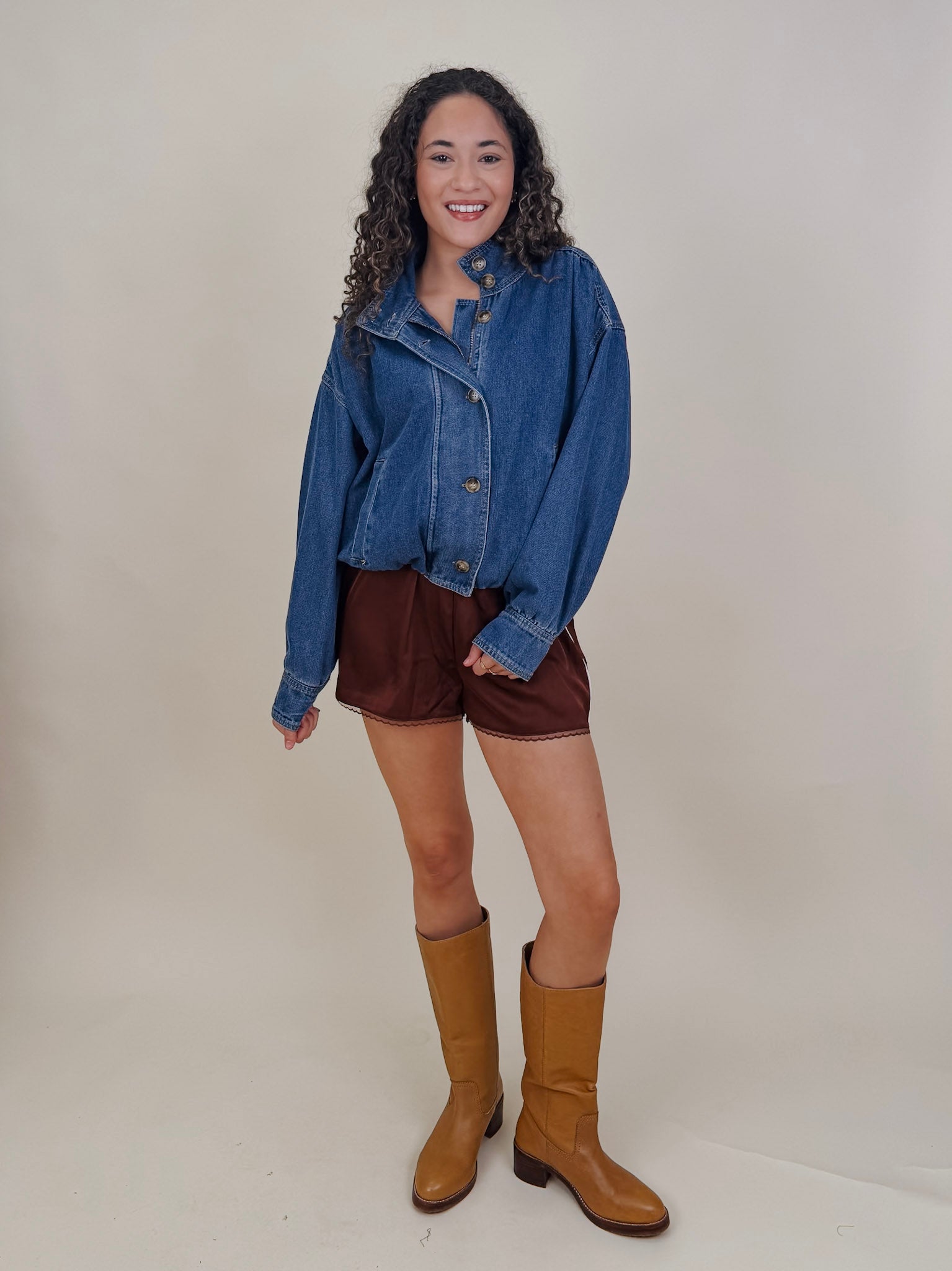 Pumpkin Patch Denim Jacket in medium wash denim with tortoise buttons over a hidden zip front, gathered shoulders, welt pockets, and an elastic bubble hem