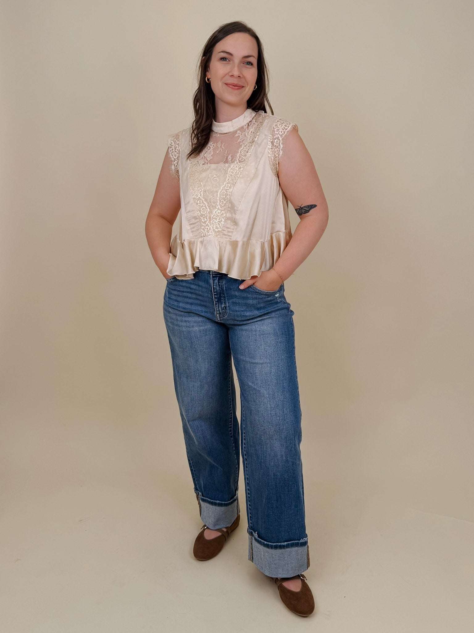 So Long London Blouse in champagne satin with eyelash lace panels, a mock neckline, cap sleeves, and a ruffled peplum hem with a ribbon tie back