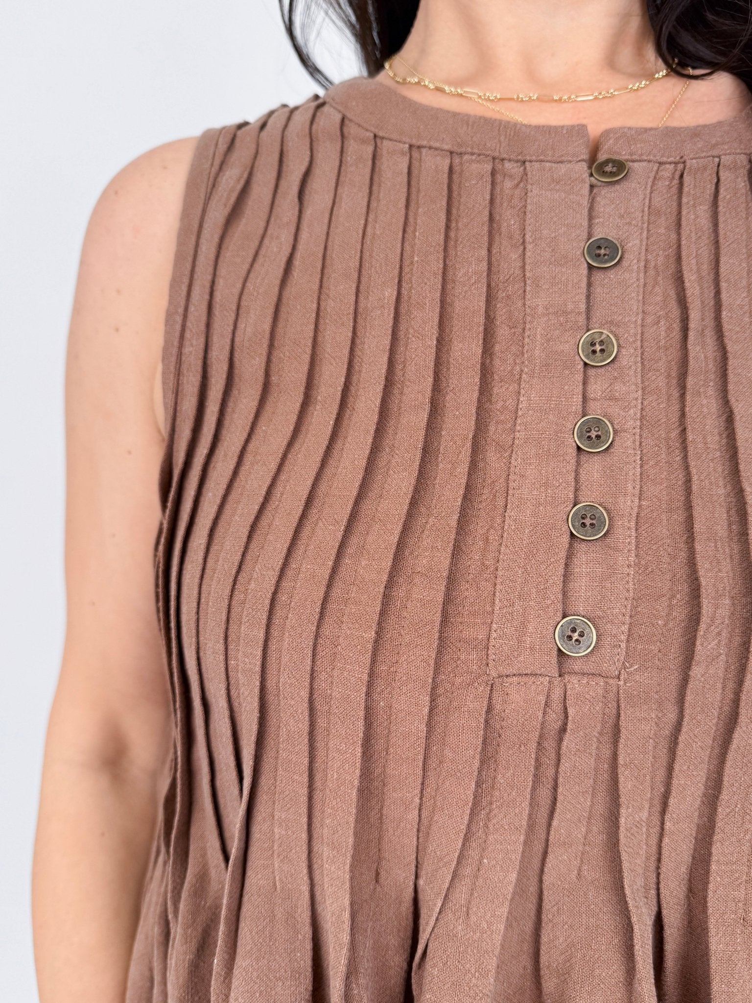 Betsey Pleated Blouse in mocha and off white with vertical pleated front, antique button detail, and raw frayed hem