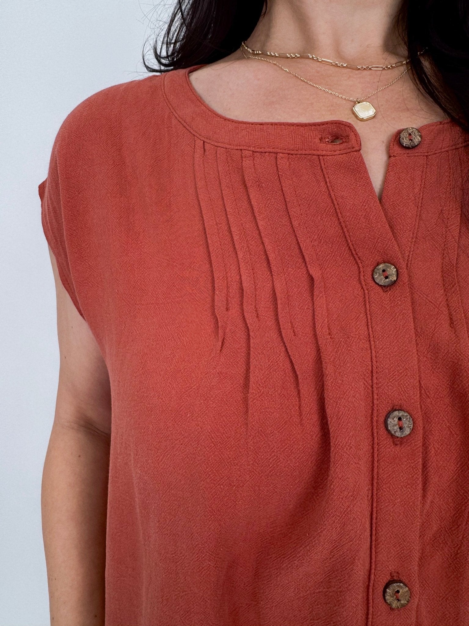 Astrid Button Down Blouse in brick with notch neckline, wooden button front, pintuck detail, and relaxed cap sleeves