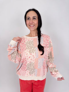 Take A Risk Patchwork Top in floral patchwork print with pink, peach, periwinkle, and olive tones with crew neckline and ribbed trim